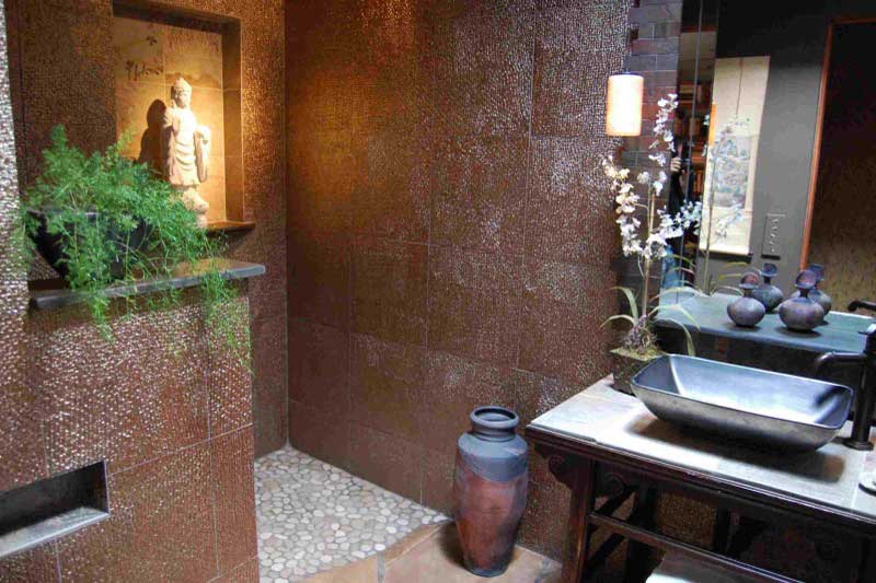 A bathroom with a mirror and a vase on the counter