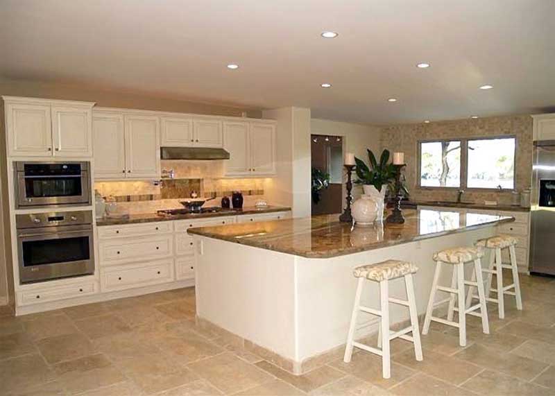 A kitchen with white cabinets and granite counter tops.