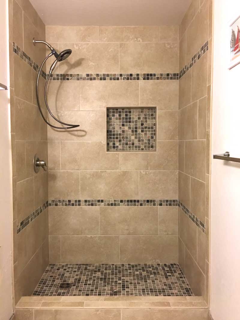 A bathroom with a shower and tiled walls.