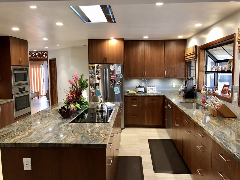 A kitchen with brown cabinets and granite counter tops.